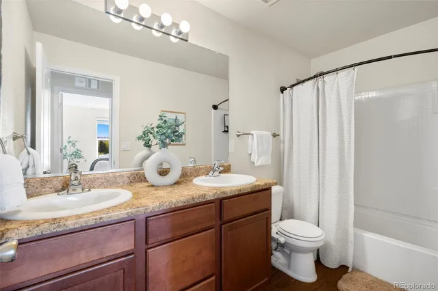 a bathroom with a granite countertop sink a toilet and a mirror