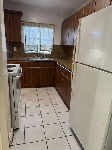 a kitchen with a refrigerator a stove a sink a washer and dryer