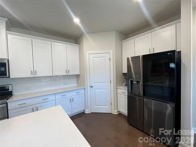 a kitchen with a refrigerator and a stove top oven