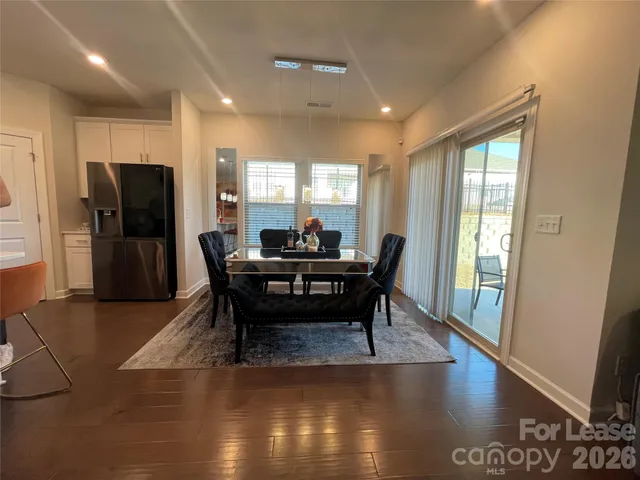 a dining room with furniture and a floor to ceiling window