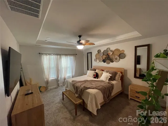 a bedroom with bed tv and window