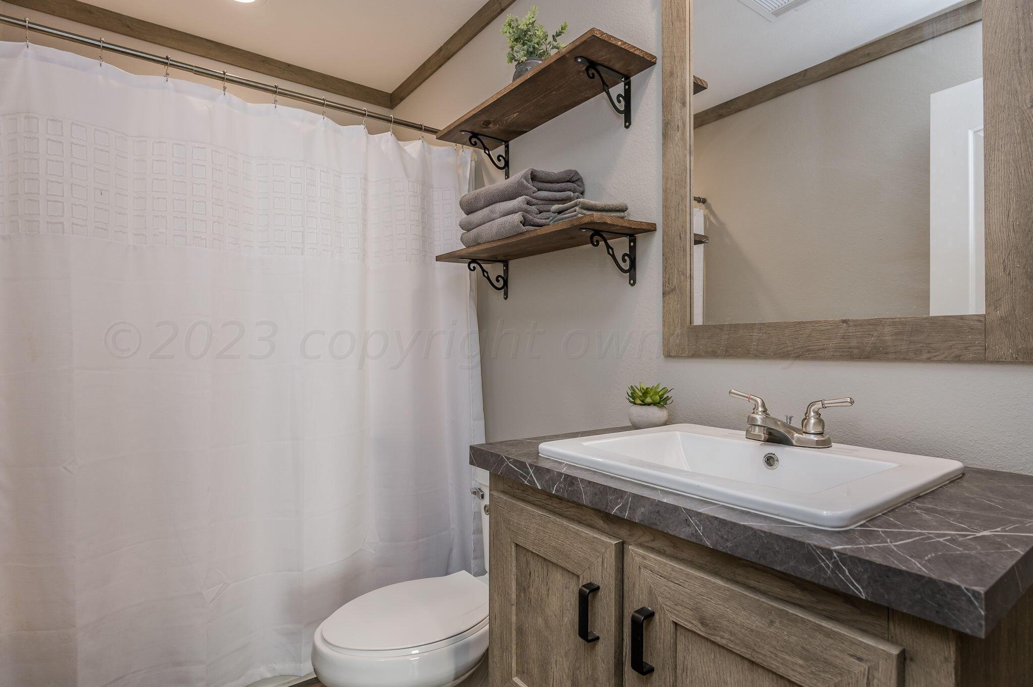 3557 Estates Drive Amarillo, TX 79124 - Photo 17 of 24 a bathroom with a sink a toilet and shower