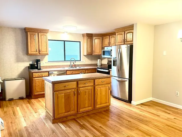 a kitchen with a refrigerator sink and cabinets