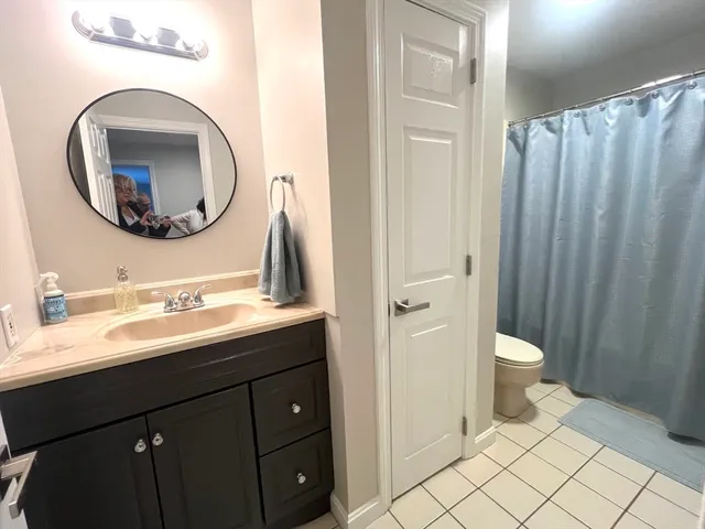 a bathroom with a toilet a sink and a mirror