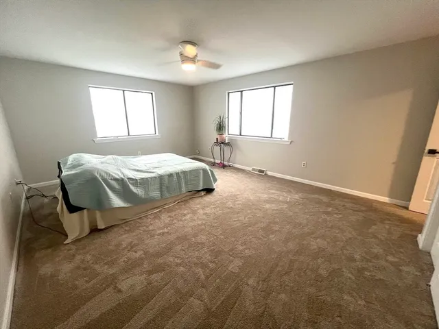 a spacious bedroom with a bed and window