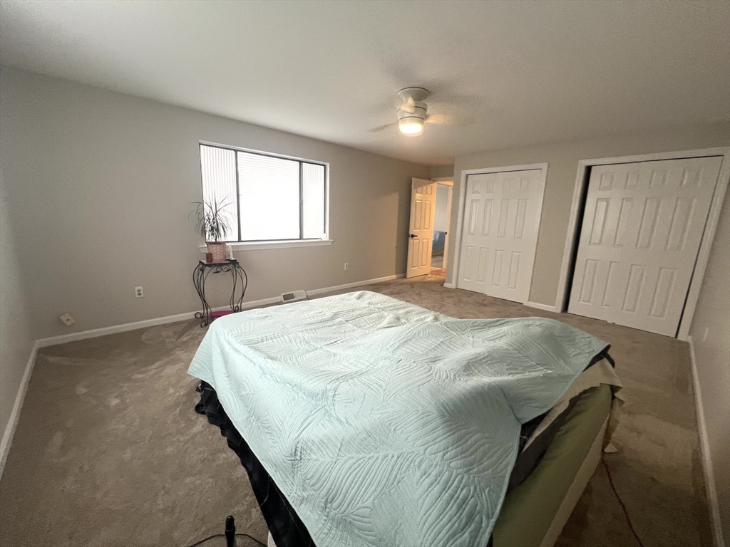 123 Chapin Road, Unit 1A4 Hudson, MA 01749 - Photo 22 of 32 a bed sitting in a spacious bedroom next to a window