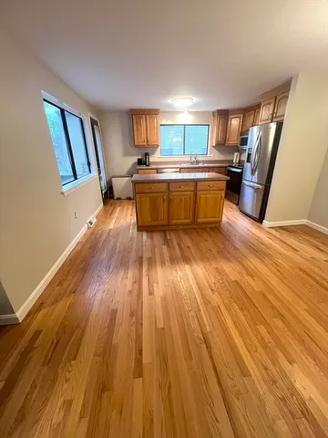 a view of a kitchen with furniture and wooden floor