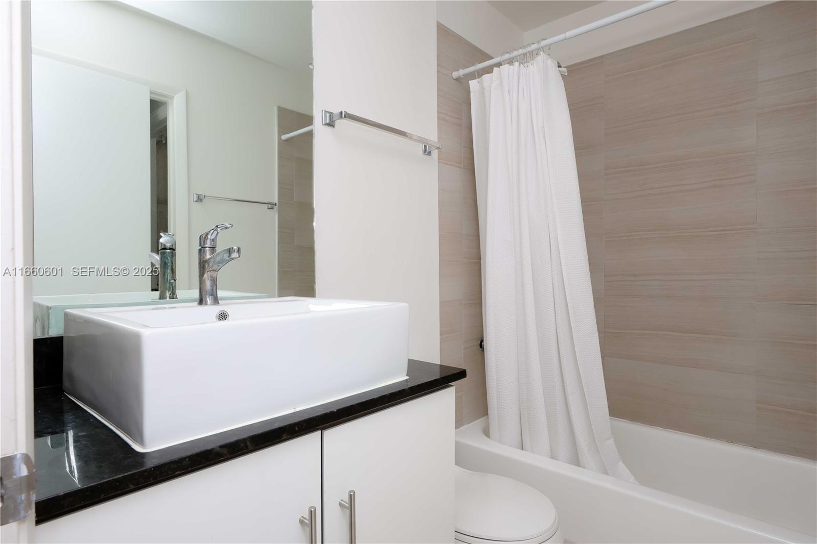 446 Southwest 113th Way, Unit 446 Pembroke Pines, FL 33025 - Photo 21 of 39 a bathroom with a sink a mirror and a bathtub
