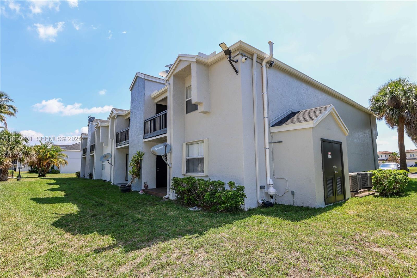 446 Southwest 113th Way, Unit 446 Pembroke Pines, FL 33025 - Photo 35 of 39 a view of a house with brick walls and a yard with plants
