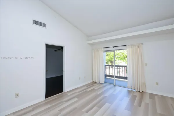 an empty room with wooden floor and a window