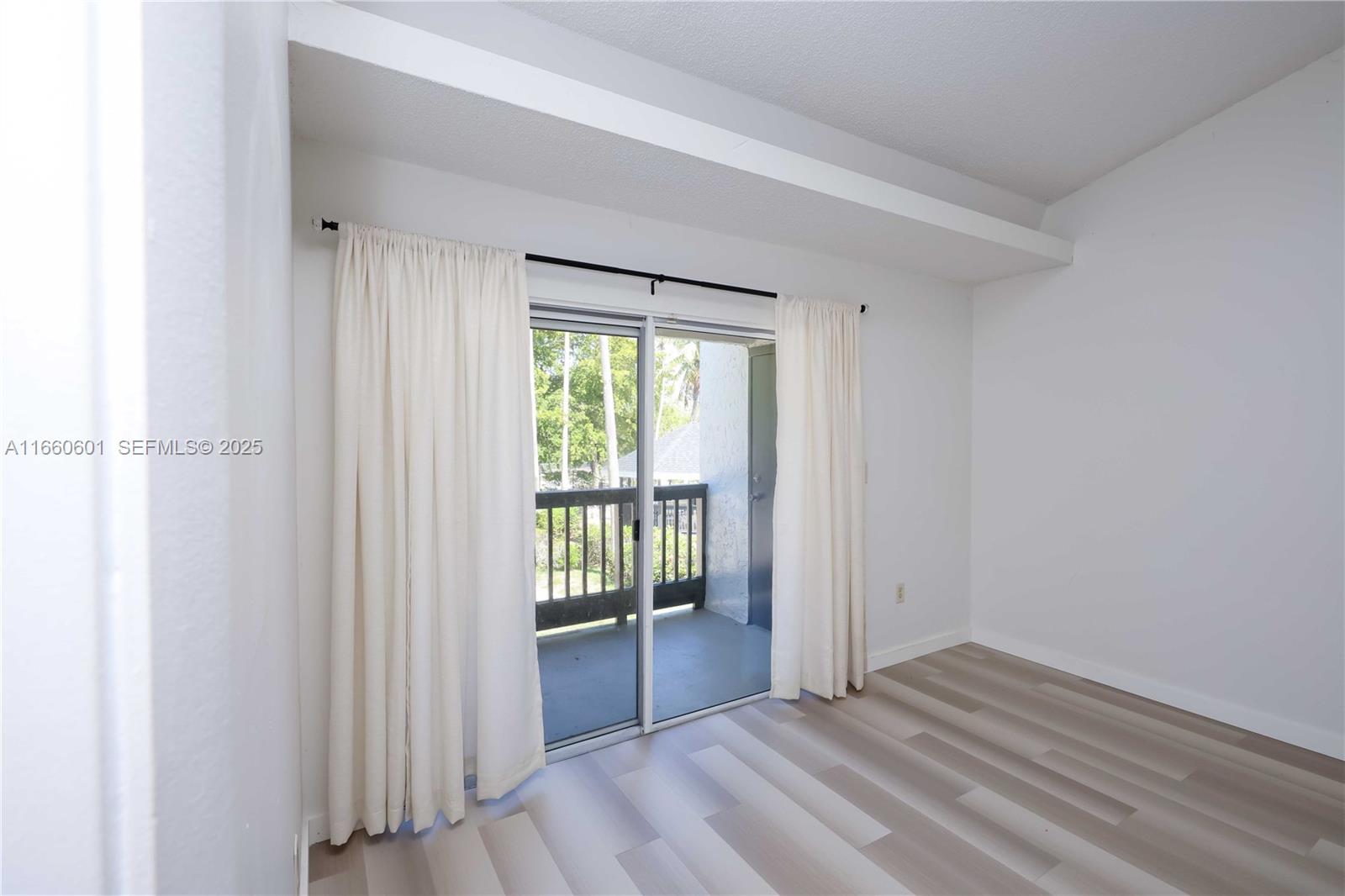 446 Southwest 113th Way, Unit 446 Pembroke Pines, FL 33025 - Photo 5 of 39 a view of an empty room with wooden floor and a window