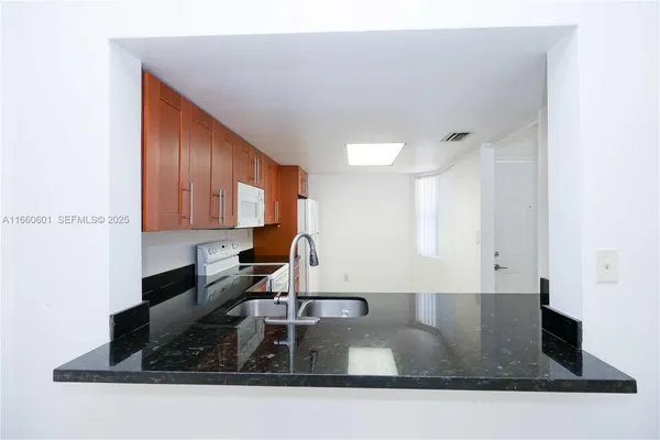 a kitchen with kitchen island a sink a stove and a microwave