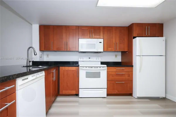 a kitchen with stainless steel appliances granite countertop a refrigerator stove a sink dishwasher and a microwave oven on the blue kitchen countertops
