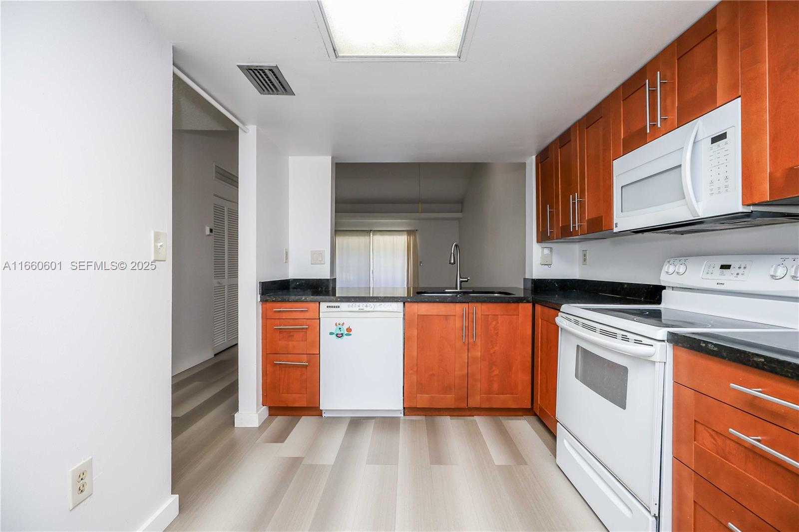 446 Southwest 113th Way, Unit 446 Pembroke Pines, FL 33025 - Photo 9 of 39 a kitchen with stainless steel appliances granite countertop a stove a sink and a refrigerator