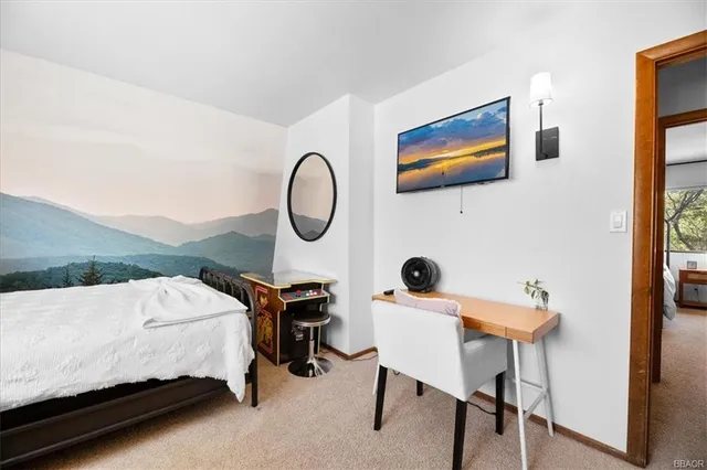 a bedroom with a bed a chair and a potted plant