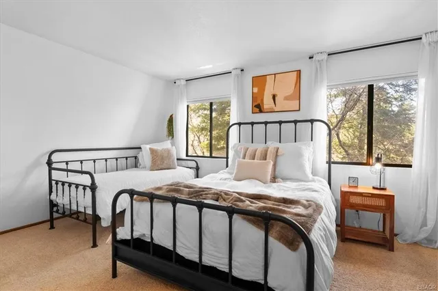 a bed sitting in a bedroom next to a window