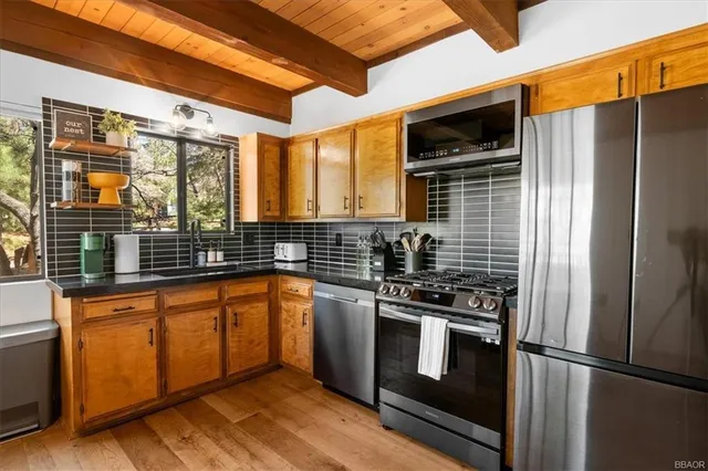 a kitchen with stainless steel appliances granite countertop a refrigerator and a sink
