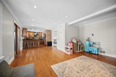 a view of kitchen with kitchen island wooden floor and stainless steel appliances