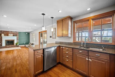 a living room with furniture appliances and wooden floor