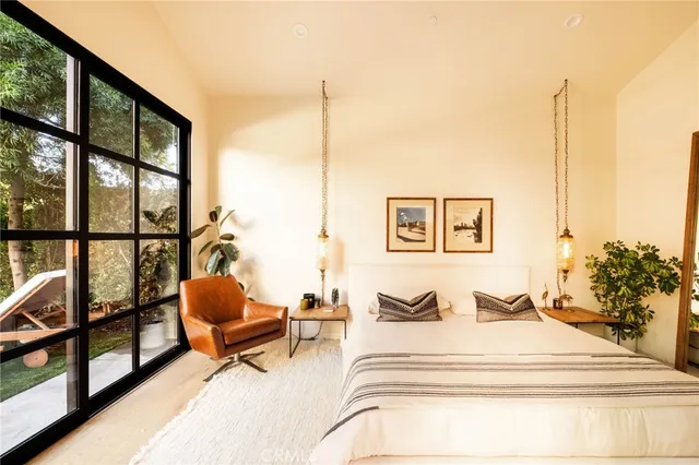 a bedroom with furniture and a large window