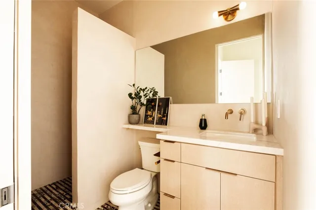 a bathroom with a sink toilet vanity and mirror