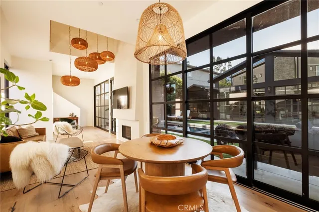 a view of a dining room and livingroom with furniture wooden floor and a chandelier