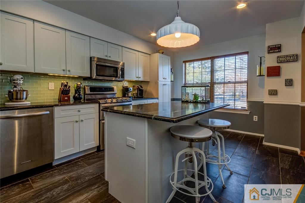 170 Salem Road North Brunswick, NJ 08902 - Photo 3 of 25 a kitchen with kitchen island granite countertop a sink cabinets and wooden floor