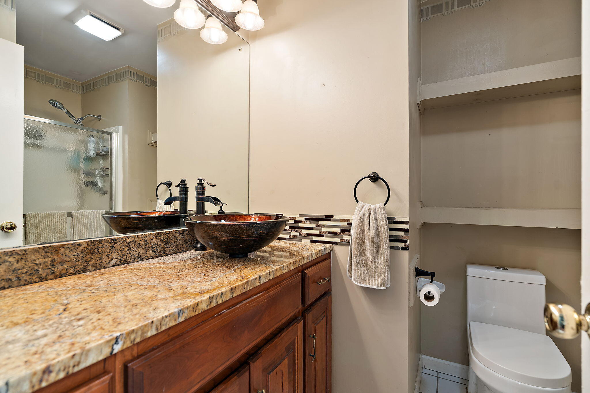 733 South Indiana Avenue Griffith, IN 46319 - Photo 30 of 48 a bathroom with a granite countertop sink a toilet and a mirror