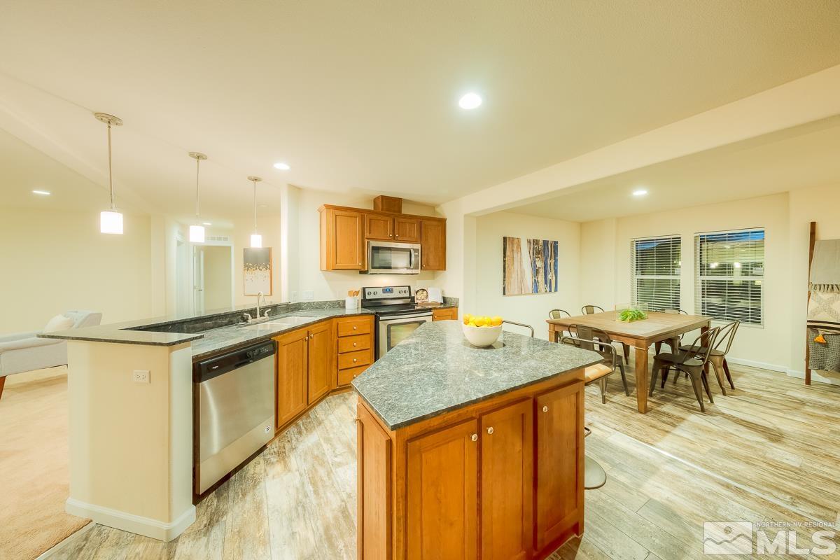 a kitchen with stainless steel appliances granite countertop sink stove and white cabinets with wooden floor