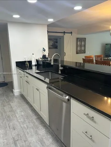 a kitchen with granite countertop a sink and cabinets