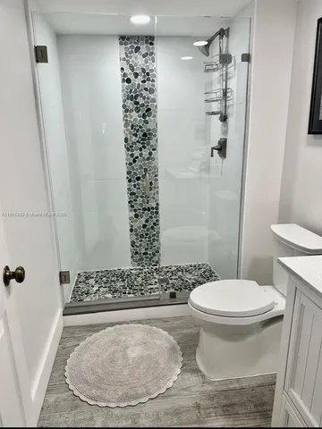 a bathroom with a toilet and a shower