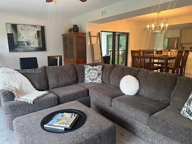 a living room with furniture a lamp and large windows