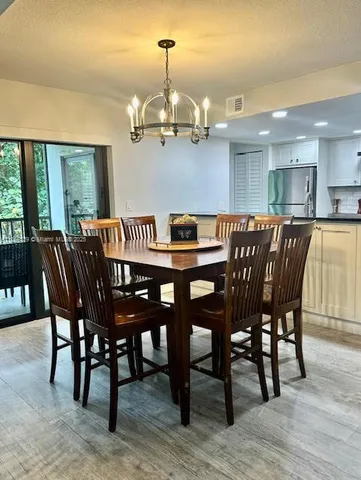 a view of a dining room with furniture wooden floor and chandelier
