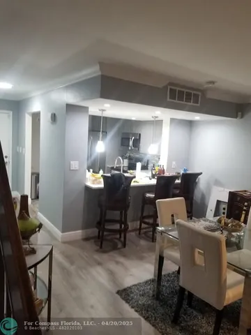 a living room with a couch and a dining table with wooden floor