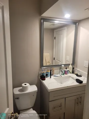 a bathroom with a sink mirror and toilet