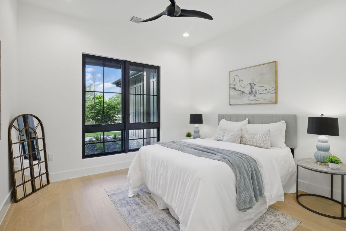 7009 Daugherty Street Austin, TX 78757 - Photo 22 of 33 a bedroom with a large bed and a balcony next to a window