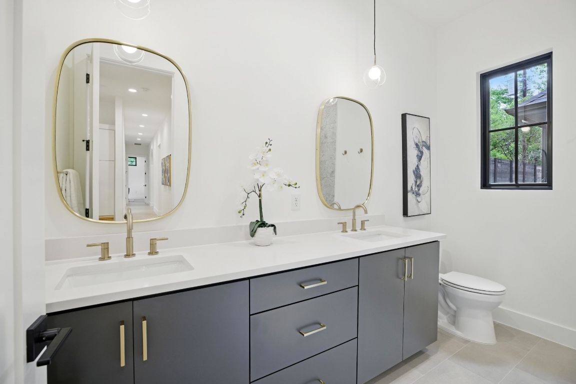 7009 Daugherty Street Austin, TX 78757 - Photo 25 of 33 a bathroom with a double vanity sink and a mirror