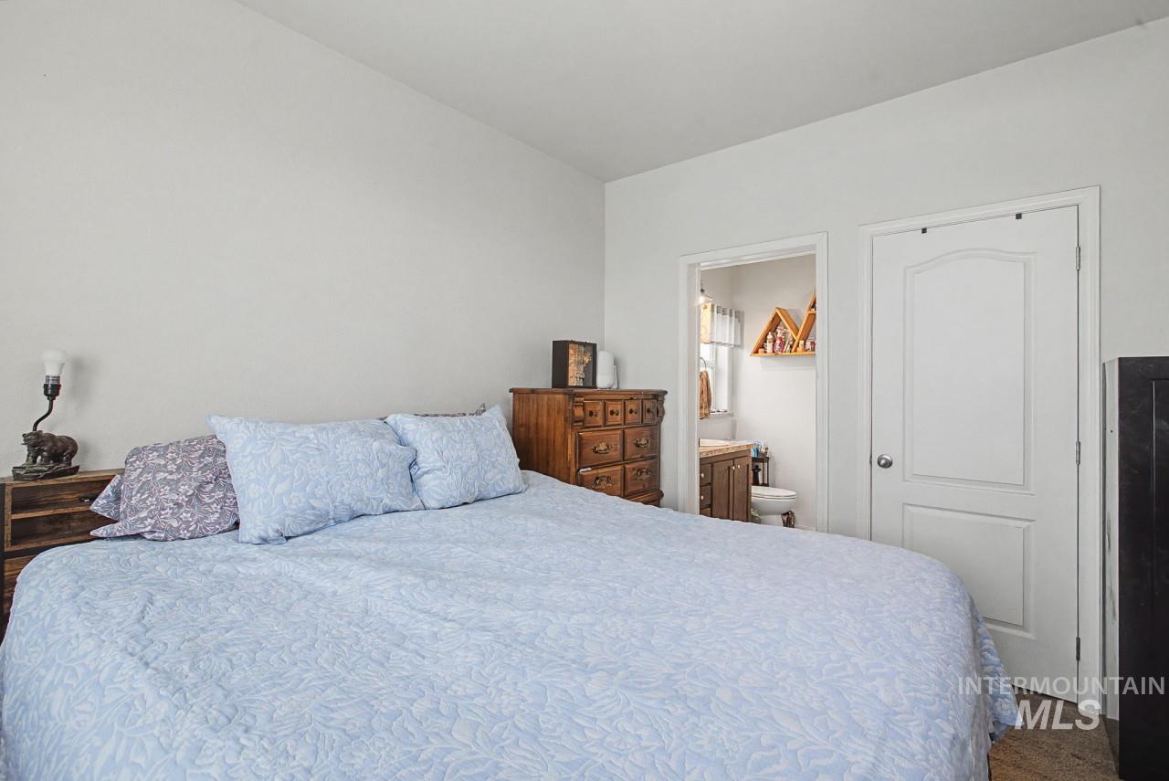 1224 1/2 Burrell Avenue Lewiston, ID 83501 - Photo 11 of 28 Bedroom with connected bathroom and dark colored carpet