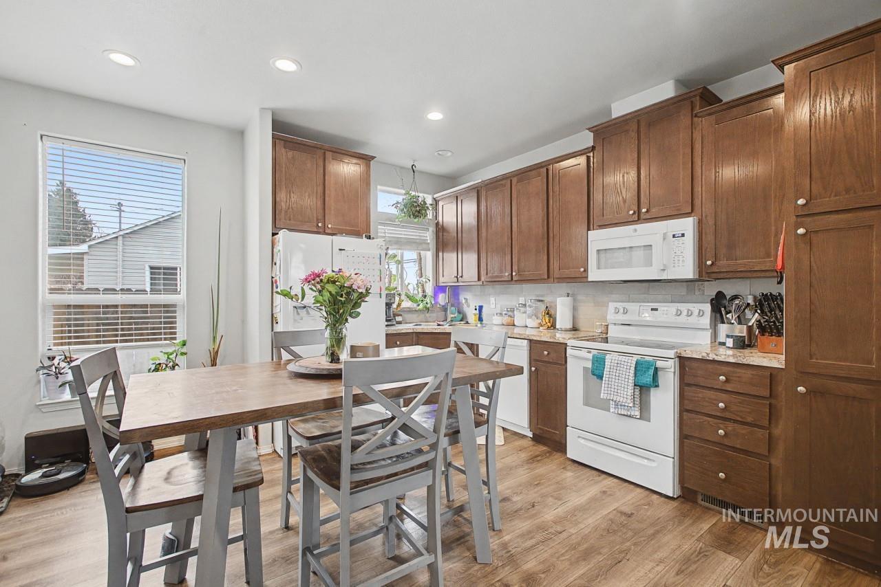 1224 1/2 Burrell Avenue Lewiston, ID 83501 - Photo 6 of 28 Kitchen with white appliances, light wood-style flooring, backsplash, recessed lighting, and brown cabinets