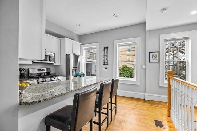 a kitchen with stainless steel appliances granite countertop sink microwave and wooden cabinets