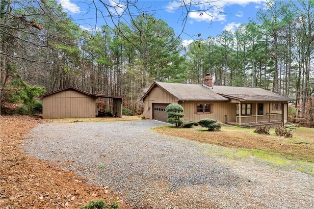 a view of a house with a yard and large tree