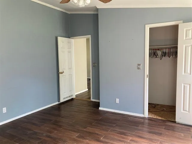 an empty room with wooden floor and closet