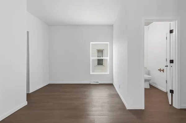 an empty room with wooden floor and a window
