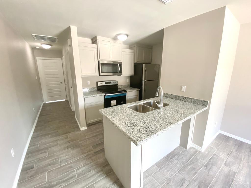 1105 West Kennedy Street, Unit 19 Pharr, TX 78577 - Photo 3 of 11 a kitchen with stainless steel appliances granite countertop a sink stove and refrigerator