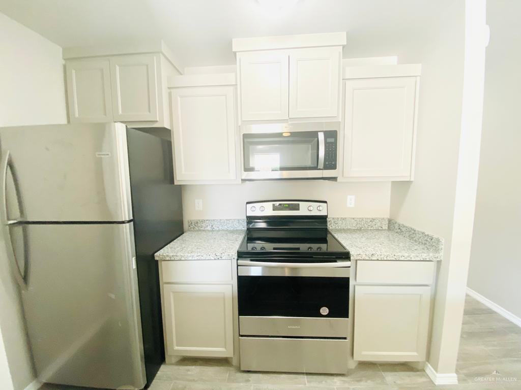 1105 West Kennedy Street, Unit 19 Pharr, TX 78577 - Photo 6 of 11 a kitchen with a stove refrigerator and microwave