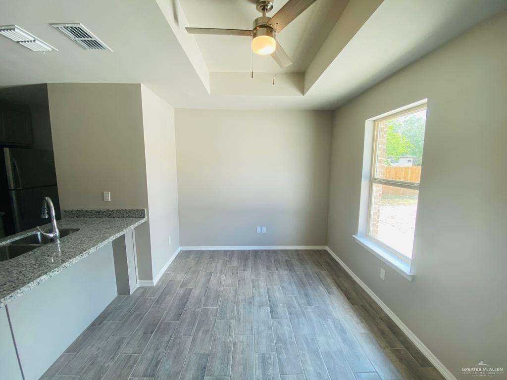 1105 West Kennedy Street, Unit 19 Pharr, TX 78577 - Photo 7 of 11 an empty room with wooden floor and windows