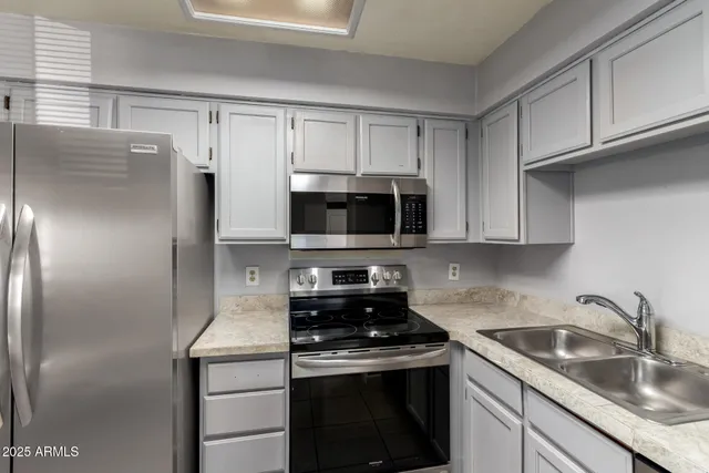 a kitchen with granite countertop a refrigerator and a stove