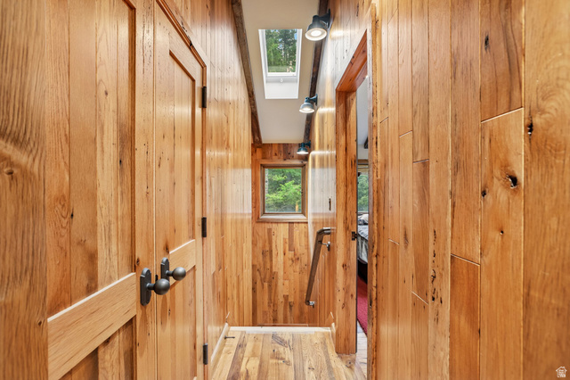 10205 East Moose Loop Road Salt Lake City, UT 84121 - Photo 26 of 50 Wood-paneled hallway featuring matching wood-finish flooring, a skylight, and track lighting