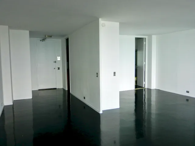 an empty room with wooden floor and door