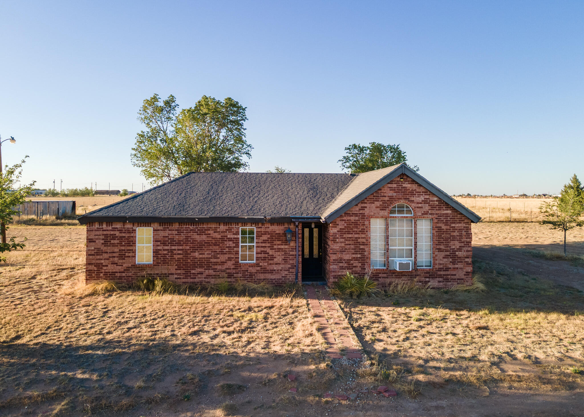 6917 Highway 114 Lubbock, TX 79407 - Photo 1 of 45 a front view of a house with a yard